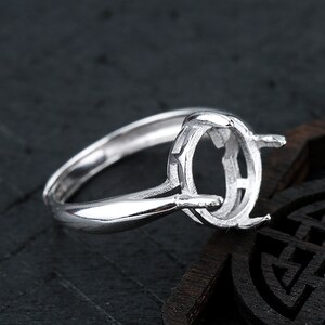 Könnte beinhalten: Ein silberner Ring mit einer ovalen Fassung für einen Edelstein. Der Ring ist so konzipiert, dass er einen Cabochon-Stein hält.