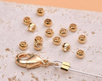 May include: Gold-toned metal beads and a clasp for jewelry making. The beads are round and have a smooth finish. The clasp is a lobster claw style.