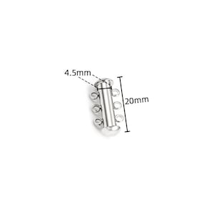 May include: A silver-toned metal jewelry clasp featuring a cylindrical tube design with three small circular loops on each side. The component is labeled with dimensions of 4.5mm for the width and 20mm for the total length of the piece.