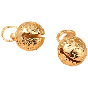 Op de afbeelding: Twee gouden belletjes met een decoratief ontwerp. De belletjes hebben een lus aan de bovenkant om aan een project te bevestigen.