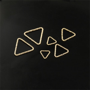 Könnte beinhalten: Ein Satz mit sechs goldfarbenen, dreieckigen Sprungringen. Die Ringe sind in verschiedenen Größen und haben ein gedrehtes Seil-Design.