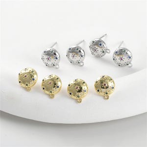 May include: Six pairs of earrings with a round, gold-toned base and a silver-toned base. The earrings have a floral design with colorful gemstones.