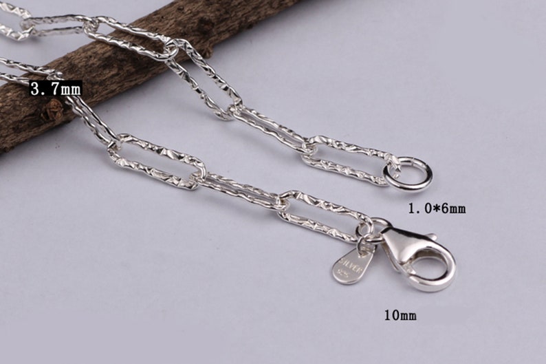 Pode incluir: Pulseira de corrente de prata com um design de elo retangular texturizado. A corrente tem 3,7 mm de largura e o fecho 10 mm de comprimento. O fecho &eacute; do tipo lagosta com um anel na extremidade.