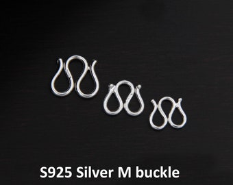 May include: Three silver S925 M buckles of different sizes. The buckles are shaped like a double loop.