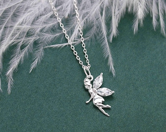 May include: A silver necklace with a delicate fairy pendant adorned with clear cubic zirconia stones. The fairy is depicted with outstretched wings and a flowing dress.