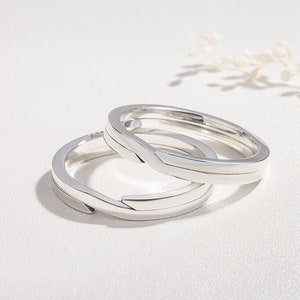 Pu&ograve; includere: Due anelli intrecciati in argento, progettati per adattarsi come un set abbinato. Gli anelli sono lisci e hanno un design semplice e moderno.