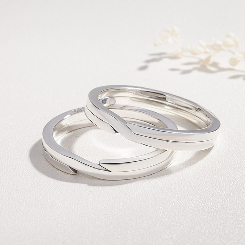 Pu&ograve; includere: Due anelli intrecciati in argento, progettati per adattarsi come un set abbinato. Gli anelli sono lisci e hanno un design semplice e moderno.