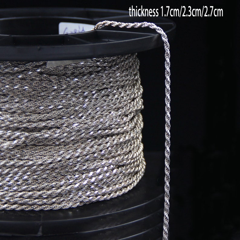 May include: A spool of silver-colored rope with a twisted design. The rope is coiled around a black plastic spool. The text on the image reads "thickness 1.7cm/2.3cm/2.7cm".