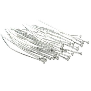 Puede incluir: Un mont&oacute;n de alfileres de cabeza redonda de color plateado. Los alfileres est&aacute;n dispuestos en un patr&oacute;n aleatorio y todos son del mismo tama&ntilde;o.