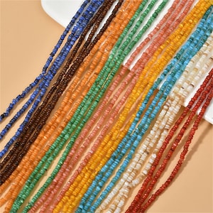 May include: Assortment of colorful beads in various shades of blue, green, orange, red, and white. The beads are small and round, and they are strung together on a string.