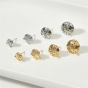 Puede incluir: Surtido de engastes para pendientes de oro y plata con un diseño circular perforado. Los engastes están disponibles en diferentes tamaños.