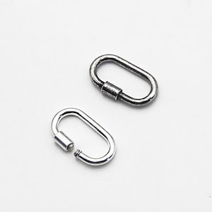 May include: Two oval-shaped, silver-colored carabiner clasps. One clasp is open, revealing the screw mechanism. The other clasp is closed, with the text "S925" visible on the screw barrel. The clasps are on a white background.