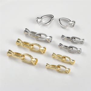 May include: A set of silver and gold metal chain connectors for jewelry making. The connectors are in various sizes and styles, including a single loop and a chain link.