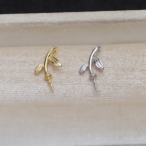 Op de afbeelding: Twee parelkappen in goud en zilver met een bladontwerp. De doppen worden gebruikt om parels aan sieraden te bevestigen.