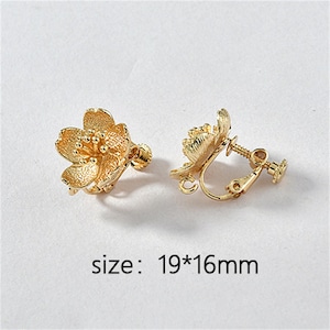 May include: A pair of gold-tone clip-on earrings featuring a flower design. The earrings measure 19mm by 16mm.