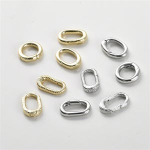 May include: Assortment of oval-shaped metal clasps in silver and gold tones. Some clasps have a textured or braided design.