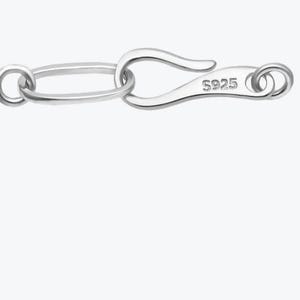 May include: A silver jewellery clasp featuring an oval link and a hook closure. The clasp is marked with "S925", denoting the metal's purity. The design is simple and elegant, suitable for necklaces or bracelets.