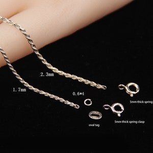May include: Close-up of silver jewelry components, including two twisted rope chains, measuring 1.7mm and 2.3mm in thickness. Also shown are two 5mm thick spring clasps, an oval tag, and a small ring. The text "ITALY" is visible on the tag.