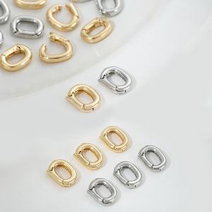 May include: A collection of gold and silver oval-shaped metal connectors. The connectors are designed to be used for jewelry making or other craft projects.