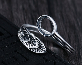 May include: A silver ring with an open circle design and a detailed floral pattern. The ring is made of sterling silver and has a unique, modern style.