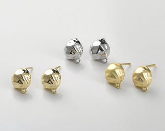 May include: Two pairs of earring findings, one pair is silver and the other is gold. The findings are round and have a small loop at the bottom.