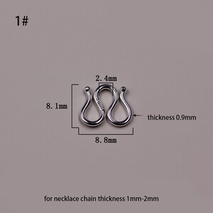 May include: Silver-toned metal connector for a necklace chain. The connector is shaped like a figure eight and measures 2.4 inches in length and 0.9 inches in thickness. The connector is designed for necklace chains that are 1 to 2 millimeters thick.