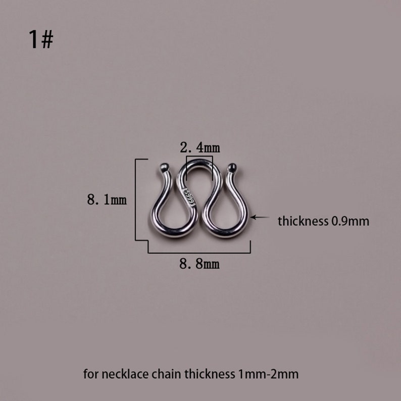 May include: Silver-toned metal connector for a necklace chain. The connector is shaped like a figure eight and measures 2.4 inches in length and 0.9 inches in thickness. The connector is designed for necklace chains that are 1 to 2 millimeters thick.