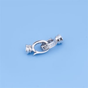 May include: Silver-toned clasp with a clear crystal accent. The clasp is designed to be used for necklaces or bracelets.