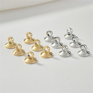 Op de afbeelding: Assortiment van gouden en zilveren springringen met een platte, ronde basis en een kleine lus aan de bovenkant. Deze ringen zijn ideaal voor het maken van sieraden en knutselen.