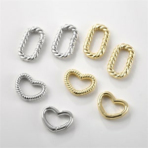 May include: A set of gold and silver metal heart and oval shaped clasps. The clasps are made of a twisted rope design.