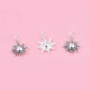 Puede incluir: Tres colgantes de sol de plata con un dise&ntilde;o detallado. Cada colgante presenta un centro redondo con una superficie texturizada en relieve y rayos que irradian.