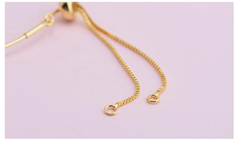 May include: A gold chain bracelet with a sliding clasp. The chain is made of small, round links.