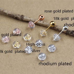 May include: Assortment of earring backs in different finishes, including rose gold plated, 18k gold plated, rhodium plated, and high-gloss silver.