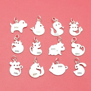 May include: Twelve silver charms depicting the Chinese zodiac animals. Each charm is a cutout of the animal and features the inscription "S925" on the back.