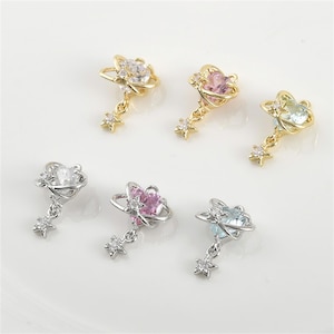 May include: Six gold and silver charm pendants featuring a crystal planet with a star charm dangling below. The planets are clear, pink, light blue, and green.