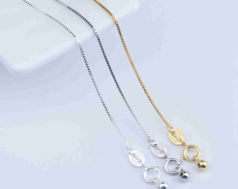 May include: Three silver chains with different clasps. The chains are on a white surface. The chains are all the same length and have a box chain design.