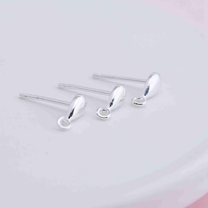 Puede incluir: Tres postes de pendientes de plata con un dije en forma de lágrima en el extremo. Cada dije tiene un pequeño anillo de salto.