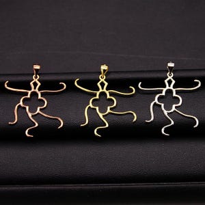 Può includere: Tre ciondoli a forma di figura umana stilizzata con un fiore al centro. I ciondoli sono in metallo e sono disponibili in oro, oro rosa e argento.