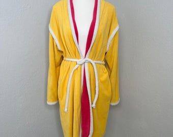 May include: A yellow terry cloth robe with a white trim and a red interior. The robe has a white tie belt and is displayed on a mannequin. The robe is a comfortable garment for lounging.