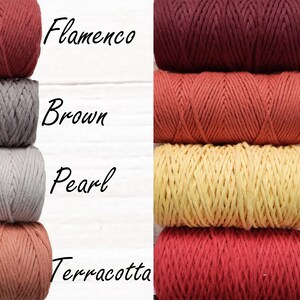 May include: Four spools of cotton rope in various colours, including terracotta, pearl, brown, and flamenco. The spools are arranged in two stacks of two, with the colours alternating. The text "Flamenco", "Brown", "Pearl", "Terracotta", "Burgundy", "Burnt orange", "Yellow lemon", and "Red" is written next to each spool.