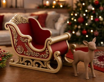 May include: A decorative sleigh featuring a deep red interior and exterior with ornate gold-colored scrollwork and trim, accompanied by a small, smooth, light brown standing deer figurine with pointed ears and a short tail, positioned to the right.