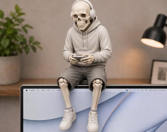 May include: A skeleton figurine wearing a beige hoodie, gray shorts, white sneakers, and white headphones, sitting on the top edge of a computer monitor while holding a small rectangular device in its hands. The figure has a light beige bone finish.