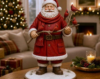 May include: A Santa Claus figurine wearing a red coat with white fur trim, a matching hat, and a brown belt. Santa holds a branch with four red cardinal birds perched on it. The figure stands on a circular base covered in white snow.