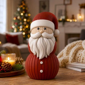 May include: A decorative Santa Claus figurine featuring a ribbed red body and hat with a white brim and pom-pom. The figure has a tan face with black bead eyes, a small nose, and a textured white mustache and long beard, with two white buttons.