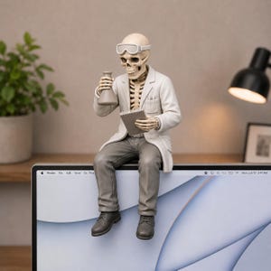May include: A skeleton figurine dressed as a scientist, wearing a white lab coat, gray trousers, and safety goggles. The figure holds a small glass flask in one hand and a notepad in the other, sitting perched on the top edge of a computer monitor.
