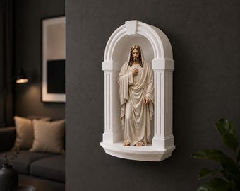 May include: A white wall-mounted arched niche featuring a sculpted figure of a bearded person with long hair, wearing a draped robe with one hand placed over the chest. The structure includes two fluted columns and a curved top canopy design.
