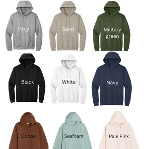 May include: A selection of nine hooded sweatshirts in various colors, including grey, sand, military green, black, white, navy, cocoa, seafoam, and pale pink. The word "Colors" is displayed at the top of the image.