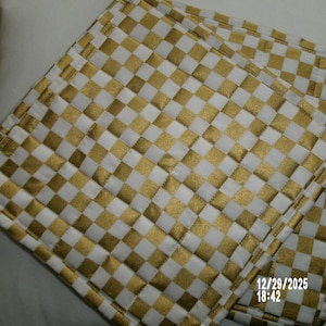 Può includere: Due presine quadrate trapuntate con un motivo a scacchi oro e bianco. Le presine sono realizzate in un materiale morbido e imbottito. Il timbro data e ora 12/29/2025 18:42 è visibile in basso a destra.