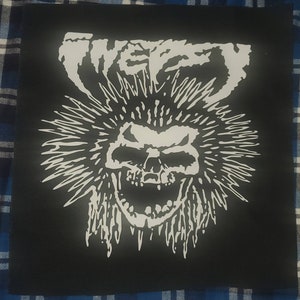 May include: Black and white iron-on patch with a skull with spiky hair and the word "WEIRD" above it.