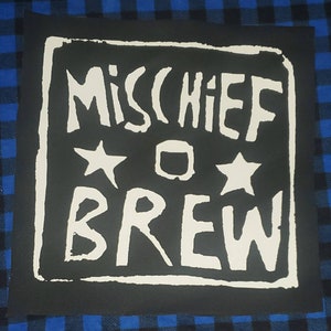 May include: Black and white patch with the text "Mischief Brew" in a white blocky font. Two white stars and a white circle are above the text.
